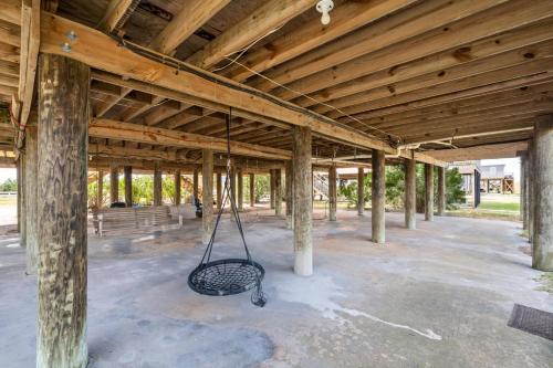 a porch with a swing hanging from a wooden ceiling at 017 The Sand House in Dauphin Island