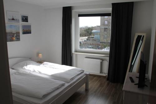 um quarto com uma cama e uma grande janela em Fewo Nordseestraße 5 em Büsum
