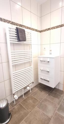 a bathroom with white cabinets and a tile floor at Fewo Voßeler in Büsum