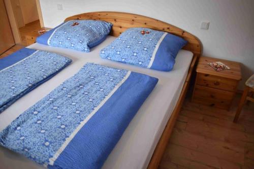 ein Schlafzimmer mit 2 Betten und blauen Kissen darauf in der Unterkunft Fewo Voßeler in Büsum