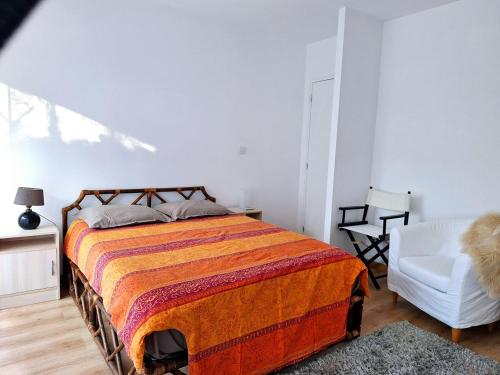 - une chambre avec un lit et une chaise blanche dans l'établissement 2 Bedroom Condomium with Terrace & Garden, à Saint-Germain-en-Laye