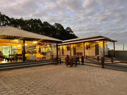 einen Pavillon mit Bänken und Tischen auf einer Terrasse in der Unterkunft Pousada Ipê Amarelo in Divisa