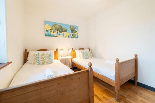 two twin beds in a room with white walls at Great Blasket, Dunquin in Dunquin