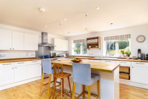 a kitchen with white cabinets and a wooden counter top at Poachers Lodge At Tapnell Farm in Yarmouth