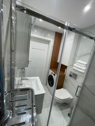 ein Bad mit einem WC, einem Waschbecken und einer Dusche in der Unterkunft Platinium Queen Aparthotel CENTRUM in Kielce