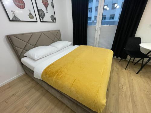 sypialnia z łóżkiem z żółtym kocem w obiekcie Platinium Queen Aparthotel CENTRUM w Kielcach