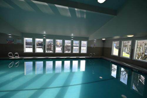 a large swimming pool in a building with windows at Edgewater Inn and Suites, an Ascend Collection Hotel in Coos Bay
