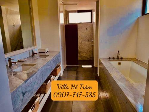 uma casa de banho com 2 lavatórios e uma banheira em Biệt thự 5PN Resort Sanctuary HỒ Tràm ll Bãi biển riêng ll hồ bơi BBQ em Xuyên Mộc