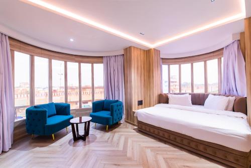 una camera con un letto e due sedie blu di Grand Dhillon Hotel a Bhilai