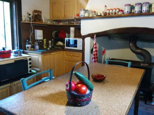 a kitchen with a table with a basket of vegetables on it at Guest House Pepeliana in Sŭbotkovtsi