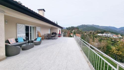 a balcony with couches and chairs on a house at Casa Panorâmica Gerês by Gerês Casas in Geres