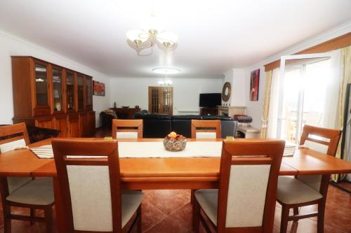 a dining room with a wooden table and chairs at Casa Panorâmica Gerês by Gerês Casas in Geres