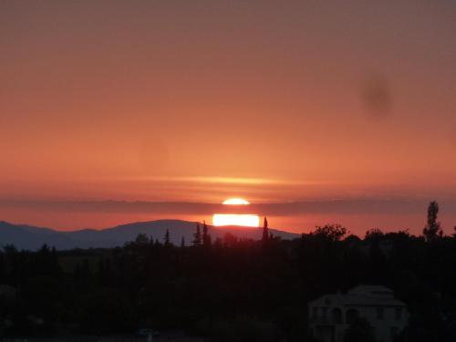 a sunset with the sun setting over the mountains at Le Figuier in Saint-Andéol-de-Berg
