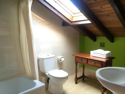 a bathroom with a white toilet and a sink at Hotel Rural Porrua in Porrúa