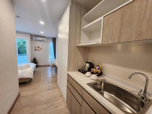 a kitchen with a sink and a room with a bed at Vicky the east ville Bangsean in Ban Hua Khao Sammuk