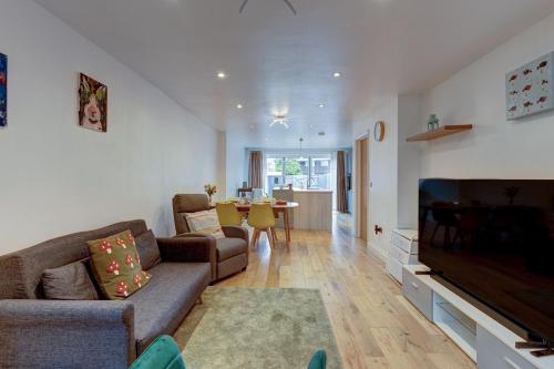 a living room with a couch and a flat screen tv at Lillies House in Oxford