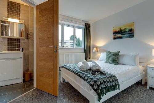a bedroom with a white bed and a window at Lillies House in Oxford