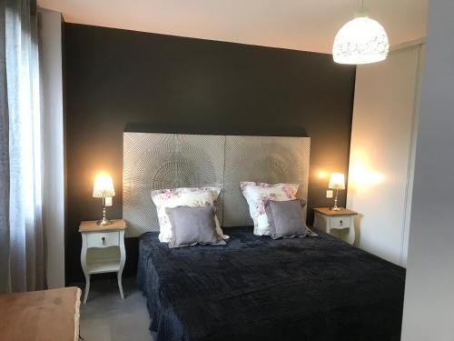 a bedroom with a bed with pillows and two lamps at Gîte A Funtana Montestremo, Balagne, Haute Corse in Manso