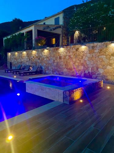 a swimming pool in a backyard at night with lights at Gîte A Funtana Montestremo, Balagne, Haute Corse in Manso