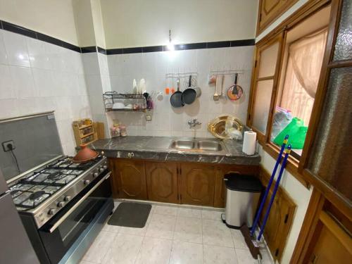 een kleine keuken met een fornuis en een wastafel bij Cozy apartment near city center in Fès