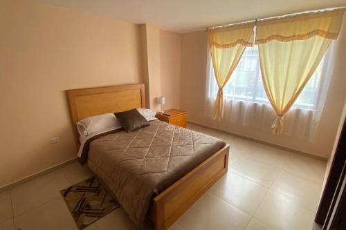 een slaapkamer met een bed en een raam bij Departamento en Baños - Domussc in Baños