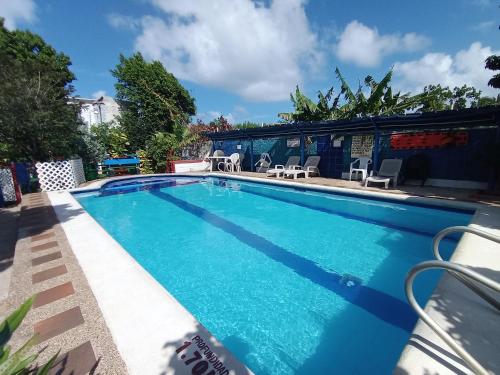 uma piscina com água azul num quintal em Hospedaje Turistico Angula Place em San Andrés
