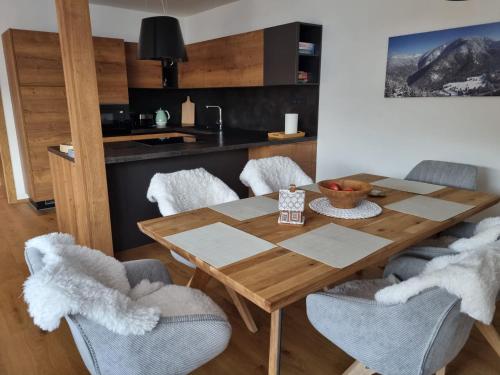 a dining room with a wooden table and chairs at Lucky Chalet Jasná luxury apartment in Demanovska Dolina