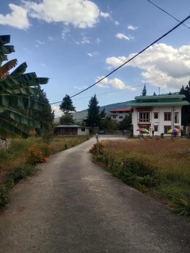 a dirt road in front of a white building at Zomsa home garden lounge in Paro