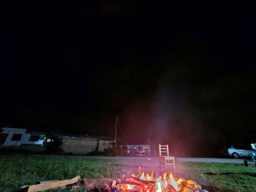 a fire is burning in a field at night at Zomsa home garden lounge in Paro