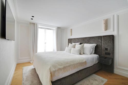 une chambre blanche avec un grand lit et une fenêtre dans l'établissement TheLander Serviced Apartments in Saint-Germain des Près - Rue Jacob, à Paris