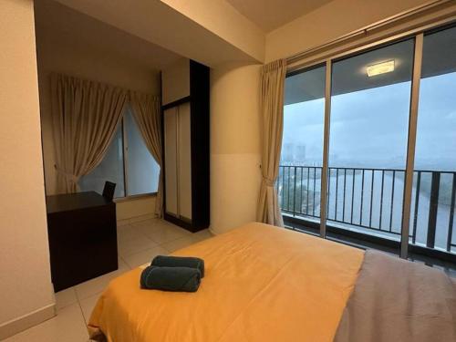a bedroom with a large bed and a balcony at Bayu Marina Resort 3 Bedroom in Johor Bahru