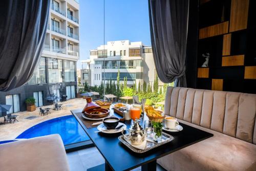 uma mesa com comida e vista para uma piscina em Dominium Hotel em Agadir