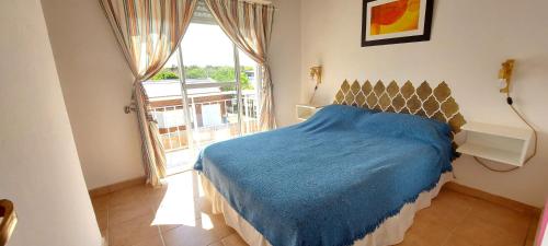 a bedroom with a blue bed and a large window at Las Grutas Star in Las Grutas