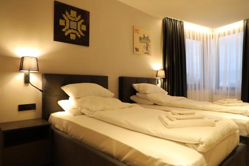 two beds sitting next to each other in a bedroom at Moaline Apartments, free parking in Sarajevo