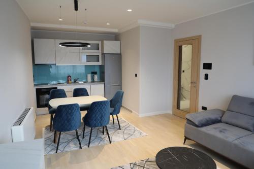 a living room with a couch and a table and chairs at Moaline Apartments, free parking in Sarajevo