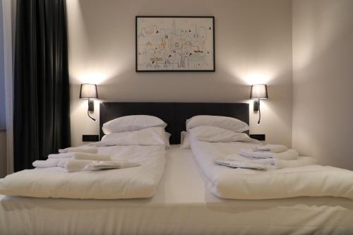 a bedroom with two beds with white sheets and pillows at Moaline Apartments, free parking in Sarajevo