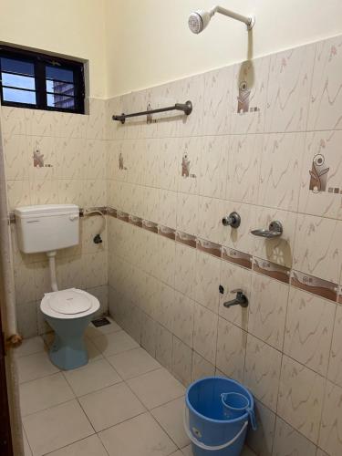 a bathroom with a toilet and a bucket at Mukalel Tourist Home in Ernakulam