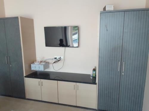 a room with two cabinets and a tv on the wall at Rivera Resort in Jammalamadugu