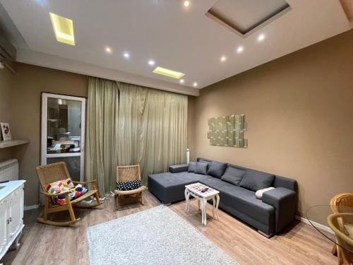 un soggiorno con divano blu e sedie di Downtown Zemun Studio Apartment a Belgrado