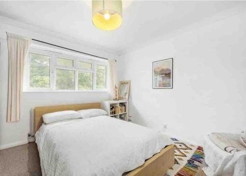 a white bedroom with a bed and a window at Hyde Park Apartment in London