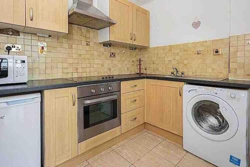 a kitchen with a washing machine and a washer at Hyde Park Apartment in London