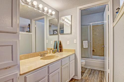 a bathroom with a sink and a toilet and a mirror at Mystic Harbor 301 in Padre Island