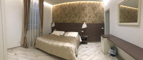 una camera con letto e specchio di Hotel Splendid a Diano Marina