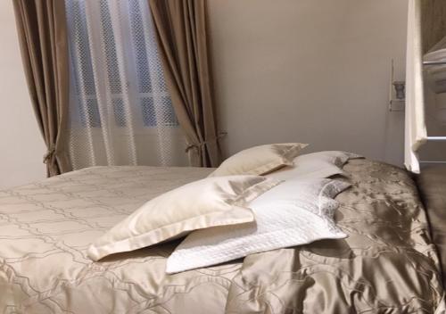 un letto con lenzuola e cuscini bianchi in una camera da letto di Hotel Splendid a Diano Marina