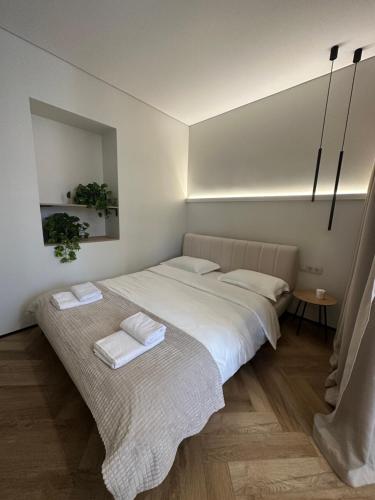 1 dormitorio con 1 cama grande y 2 toallas. en Other Apartments en Ivano-Frankivsk