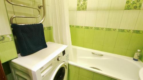 a bathroom with a washing machine next to a sink at Дачна 37,CityRooms in Bila Tserkva