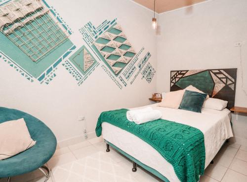 um quarto com uma cama e uma cadeira em Casa Amaranto em Panajachel