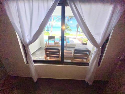 a window with a view of a patio at Casa Paraiso Punta Allen in Punta Allen