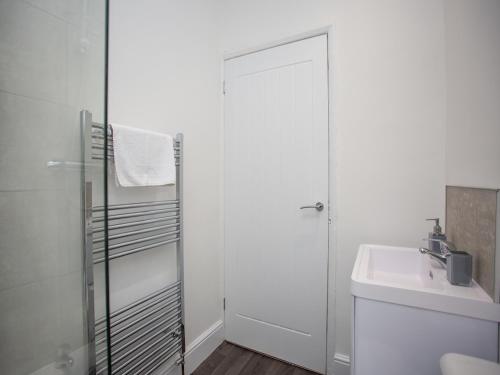 ein weißes Bad mit einem Waschbecken und einer Dusche in der Unterkunft Langley Park House, Durham in Langley Park