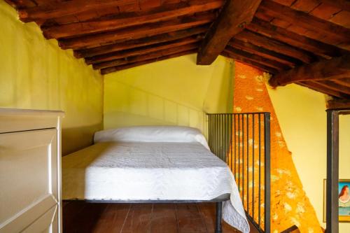 een slaapkamer met een bed in een kamer met houten plafonds bij La Castellaccia in Campagnatico
